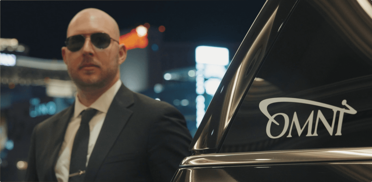 Omni Limousine chauffeur loading luggage into a vehicle.