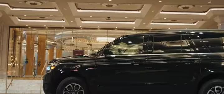 Black luxury SUV parked outside hotel entrance